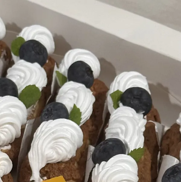 Éclair dengan whipped cream, blueberry, dan daun mint